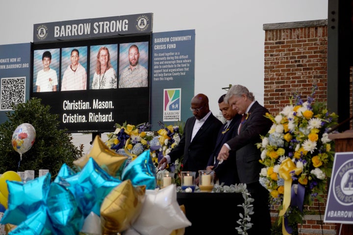 Sen. Raphael Warnock (D-Ga.) and Rep. Mike Collins (R-Ga.) light candles during a vigil for the four shooting victims at Apalachee High School.