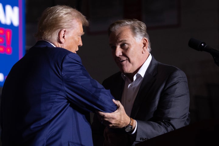 Former President Donald Trump greets Mike Rogers, the GOP nominee for a Senate seat, at an Oct. 3 rally in Saginaw, Michigan. Trump and Kamala Harris are battling for votes in the swing state.