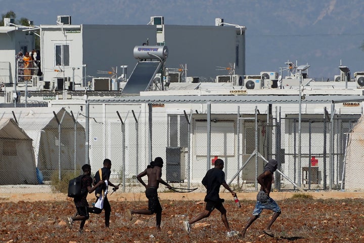 ΑΡΧΕΙΟ - Μετανάστες, κρατώντας αντικείμενα που μοιάζουν με όπλα, εγκαταλείπουν τον καταυλισμό κοντά στο χωριό Κοκκινοτριμιθιά στα περίχωρα της πρωτεύουσας Λευκωσίας, Κύπρος, Παρασκευή 28 Οκτωβρίου 2022. Ο πρόεδρος της Κύπρου Νίκος Χριστοδουλίδης δήλωσε την Τρίτη, 2 Απριλίου 2024, ότι ζήτησε προσωπικά από τον επικεφαλής του εκτελεστικού βραχίονα της Ευρωπαϊκής Ένωσης να μεσολαβήσει στις αρχές του Λιβάνου, ώστε να σταματήσουν να κατευθύνονται προς το νησιωτικό κράτος της ανατολικής Μεσογείου πλοία με Σύρους πρόσφυγες. (AP Photo/Petros Karadjias, File)