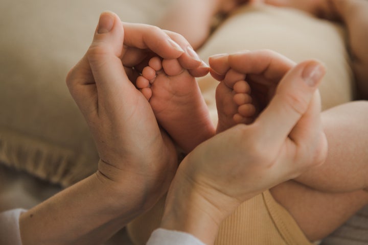 Woman holding baby feet. close up