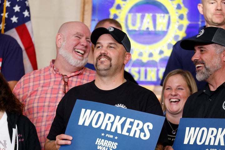 Workers wait on stage for Vice President Kamala Harris during a campaign event at the United Auto Workers Local 652 at the Capital Region International Airport in Lansing, Michigan, October 18, 2024.