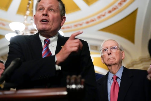 Sen. Mitch McConnell (right) listens as Sen. Steve Daines speaks during a media availability on Capitol Hill.