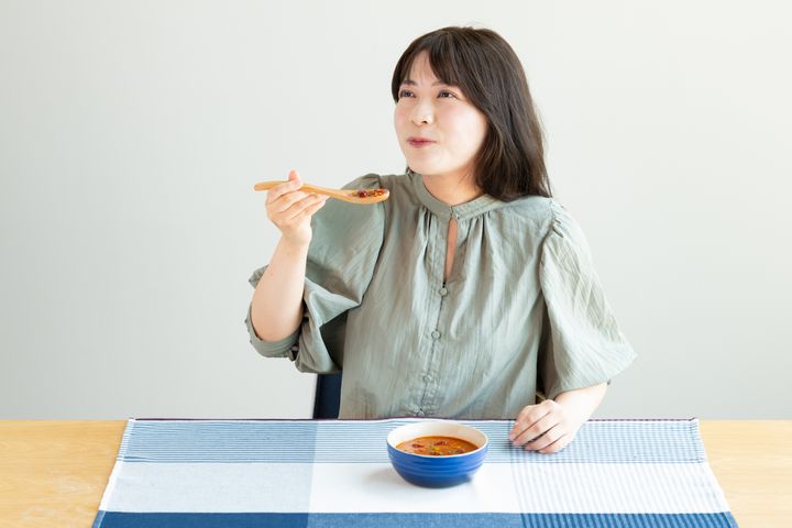 「ごろっとお豆のチリトマトスープ」を試食したハフポストスタッフ。「おいしい！食べごたえがありますね」と満足な表情だった