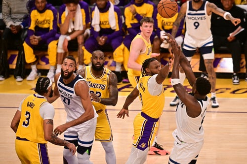 Los Angeles Lakers' US small forward #23 LeBron James (C) watches as son Los Angeles Lakers' US guard #09 Bronny James jumps to block a shot during the NBA game season opener between the Los Angeles Lakers and the Minnesota Timberwolves at Crypto Arena in Los Angeles on October 22, 2024. (Photo by Frederic J. Brown / AFP) (Photo by FREDERIC J. BROWN/AFP via Getty Images)