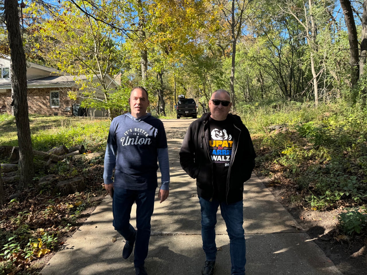 Williams, left, and Jeff Mehrhoff, business manager for IUPAT District Council 7, walk back to the van after knocking on a member's door.