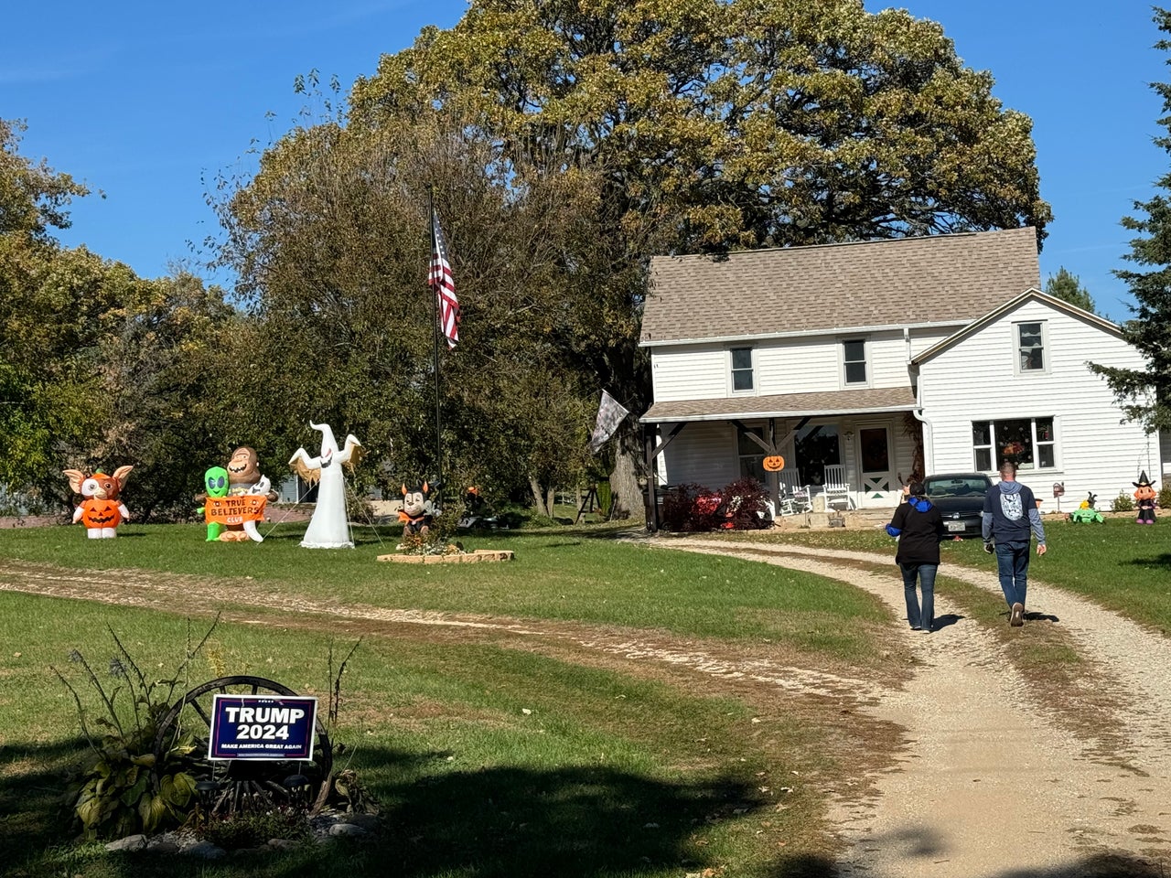 Williams, right, and Jennipher Neduzak, communications director for IUPAT District Council 7, approach the home of union members with a Donald Trump sign on their lawn.