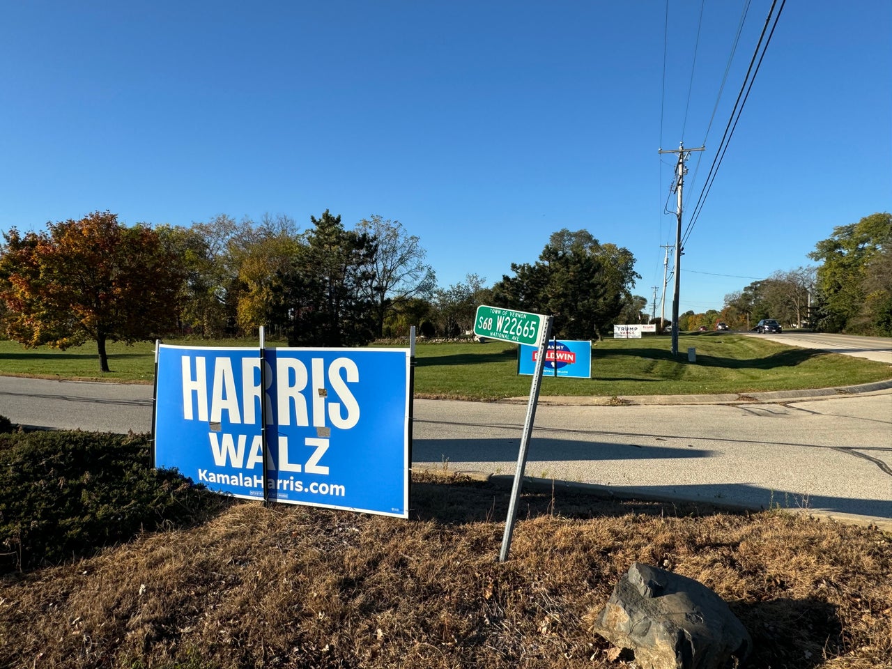 At the entrance of the IUPAT District Council 7 union hall, a neighbor's Trump sign is visible behind the union's signs for Harris and Sen. Tammy Baldwin (D-Wis.).