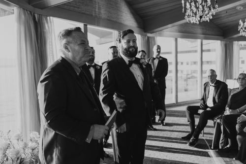 From left: Officiant Josh Mankiewicz waits with Sara Runnells' groom, Adam, for her to walk down the aisle at their wedding at the Edgewater Hotel in downtown Seattle, Oct. 12, 2024.