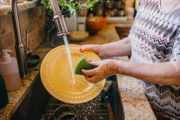 Γυναίκα πλένει τα πιάτα αφήνοντας την βρύση να τρέχει (φωτογραφία αρχείου)