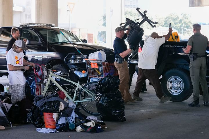 Agenten von Louisiana Wildlife and Fisheries helfen der Staatspolizei dabei, Menschen, die in einem Obdachlosenlager leben, anzuweisen, an einen anderen, vorher festgelegten Ort zu ziehen, während sie vor einem Taylor Swift-Konzert in New Orleans am Mittwoch, den 23. Oktober 2024, eine Razzia durchführen. (AP Foto/Gerald Herbert)