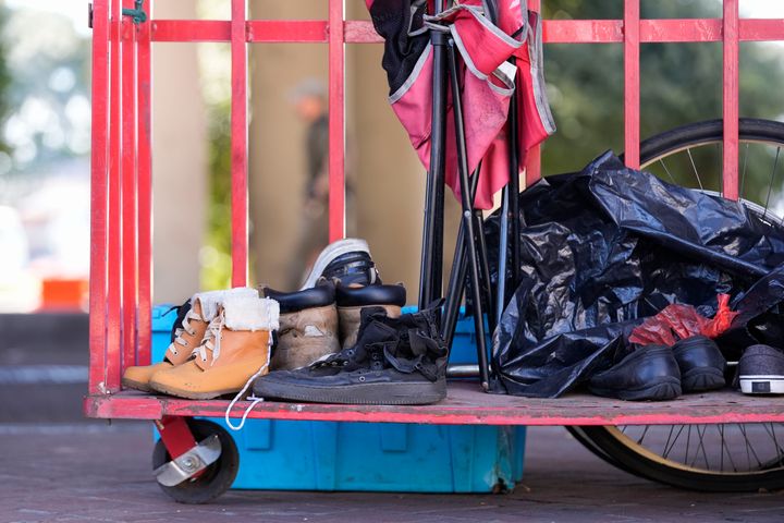 Gegenstände werden auf einen Karren gelegt, während die Staatspolizei von Louisiana Menschen, die in einem Obdachlosenlager leben, anweist, an einen anderen vorher festgelegten Ort zu ziehen, während sie vor einem Taylor-Swift-Konzert in New Orleans am Mittwoch, den 23. Oktober 2024, eine Razzia durchführen. (AP Foto/Gerald Herbert).