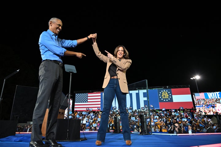 Former President Barack Obama holds hands with Democratic presidential candidate Kamala Harris during a campaign rally in the battleground state of Georgia.