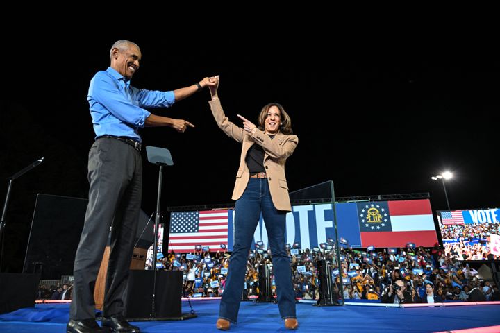 Former President Barack Obama holds hands with Vice President and Democratic presidential nominee Kamala Harris during a campaign rally in Clarkston, Georgia.