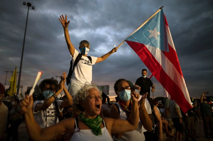 People march along Las Americas Highway in October 2021 to protest continued blackouts years after Hurricane Maria in San Juan, Puerto Rico.