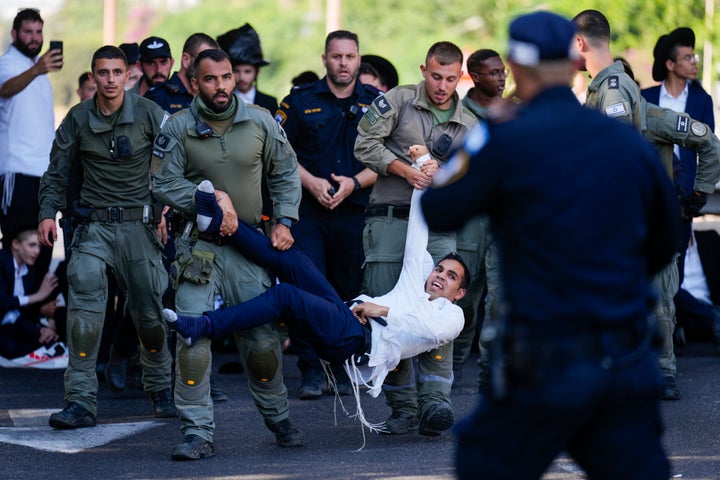 Η ισραηλινή αστυνομία διαλύει τους υπερορθόδοξους Εβραίους που μπλοκάρουν έναν αυτοκινητόδρομο κατά τη διάρκεια διαμαρτυρίας ενάντια σε πιθανές αλλαγές σχετικά με τους νόμους για τις στρατιωτικές επιστρατεύσεις από τις οποίες οι υπερορθόδοξοι παραδοσιακά έλαβαν εξαιρέσεις κοντά στο Bnei Brak, Ισραήλ, Κυριακή 2 Ιουνίου 2024. (AP Photo/Ariel Schalit)