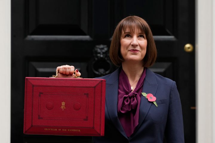 Rachel Reeves, looks up as she holds up the traditional red ministerial box containing her Budget speech outside No 11 Downing Street.