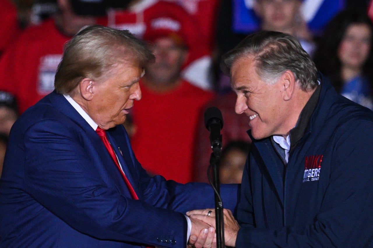 Former US President and Republican presidential candidate Donald Trump shakes hands with US Senate candidate Mike Rogers, Republican of Michigan, as Rogers takes the stage to speak during a campaign rally at the Suburban Collection Showplace in Novi, Michigan, October 26, 2024. (Photo by Drew ANGERER / AFP) (Photo by DREW ANGERER/AFP via Getty Images)