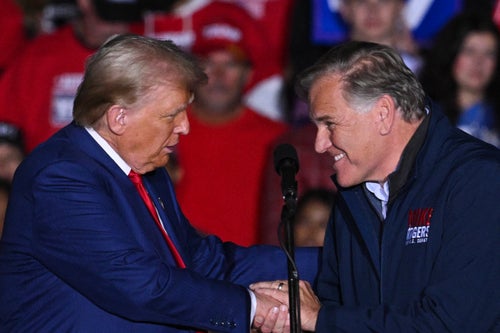 Former US President and Republican presidential candidate Donald Trump shakes hands with US Senate candidate Mike Rogers, Republican of Michigan, as Rogers takes the stage to speak during a campaign rally at the Suburban Collection Showplace in Novi, Michigan, October 26, 2024. (Photo by Drew ANGERER / AFP) (Photo by DREW ANGERER/AFP via Getty Images)