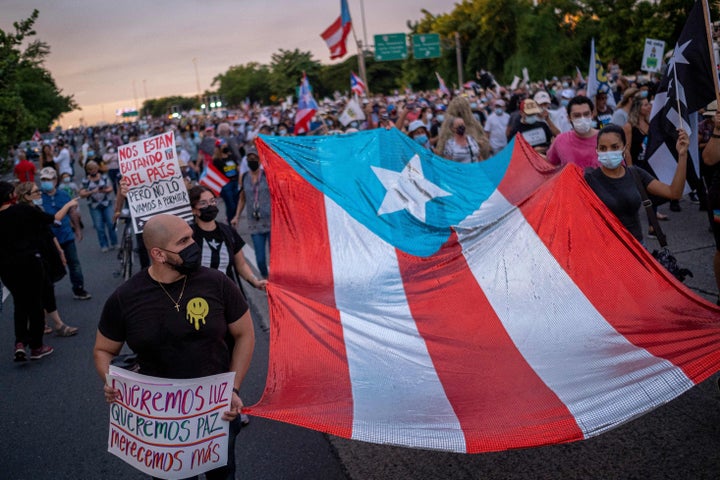 Protesters march along Las Americas Highway on Oct. 15, 2021, to demand the expulsion of power company LUMA amid a continued lack of electricity across the island.