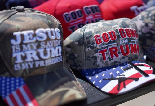 Hats reading, "God, guns and Trump," and "Jesus is my savior, Trump is my president," are sold at a campaign rally for former President Donald Trump in Vandalia, Ohio, on March 16, 2024.