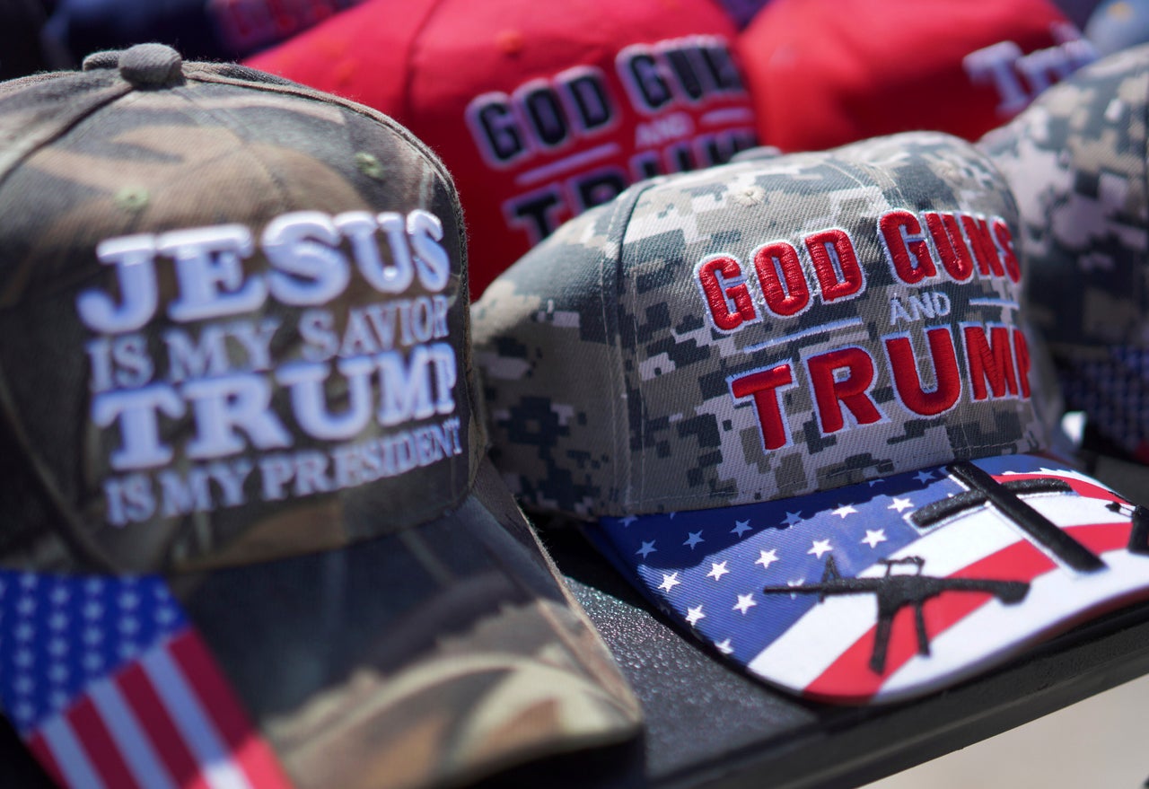 Hats reading, "God, guns and Trump," and "Jesus is my savior, Trump is my president," are sold at a campaign rally for former President Donald Trump in Vandalia, Ohio, on March 16, 2024.