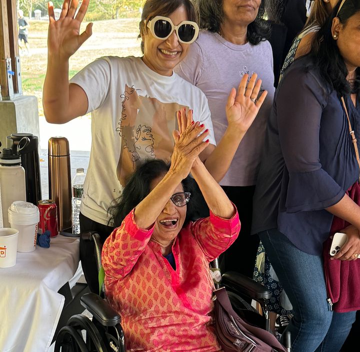 Rajesh Agrawal, seated, poses for a photo at an event organized by South Asian American Democratic groups. Agrawal's daughter, Nisha, a school teacher, stands behind her.