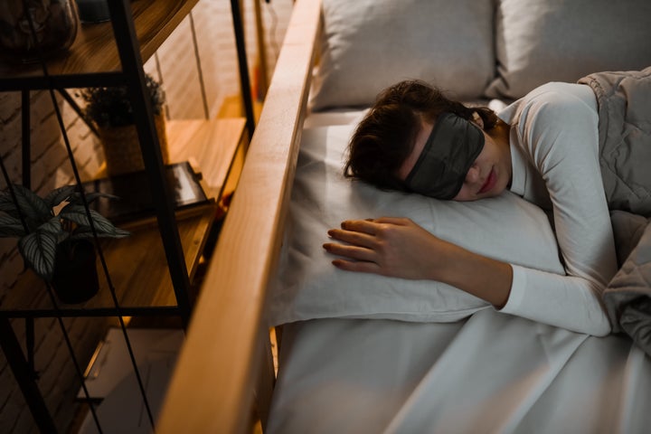 Cute Female Undisturbed By Light And Noises Wearing Ear Plugs And Eye Mask While Sleeping