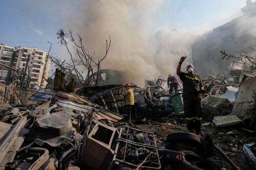 Civil defense workers extinguish a fire as smoke rises from the site of an Israeli airstrike in Dahiyeh, Beirut, Lebanon, Friday, Nov. 1, 2024. (AP Photo/Hassan Ammar)