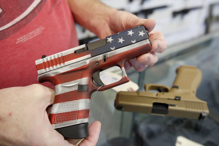 A worker restocks handguns at Davidson Defense in Orem, Utah, on March 20, 2020.