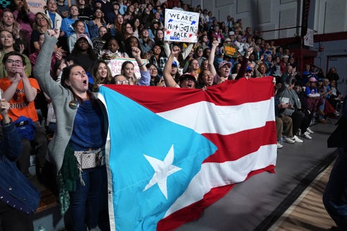Attendees holding the flag of Puerto Rico cheer as Allentown, Pa. Mayor Matt Tuerk speaks during a campaign rally for Democratic presidential nominee Vice President Kamala Harris in Memorial Hall at Muhlenberg College in Allentown, Pa., Monday, Nov. 4, 2024. (AP Photo/Susan Walsh)