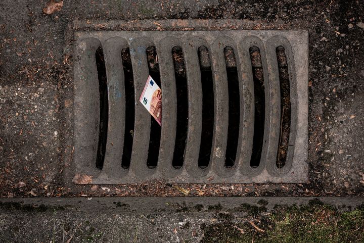 10 Euro note falling into kerbside grille.