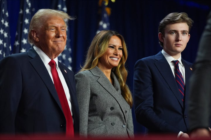 Republican presidential nominee former President Donald Trump, former first lady Melania Trump and Barron Trump listen at an election night watch party at the Palm Beach Convention Center, Wednesday, Nov. 6, 2024, in West Palm Beach, Fla. (AP Photo/Evan Vucci)