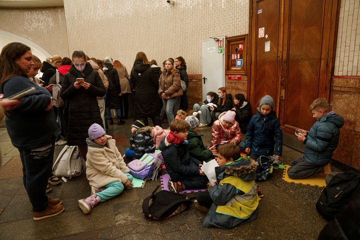 Children sit on a floor inside Arsenalna metro station during air alert in Kyiv, Ukraine on Wednesday.