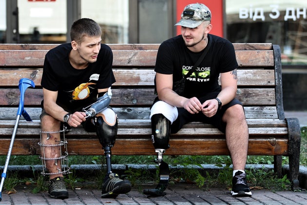 Ukrainian military veterans with amputations rest on bench on Khreshchatyk street in August in Kyiv, Ukraine.