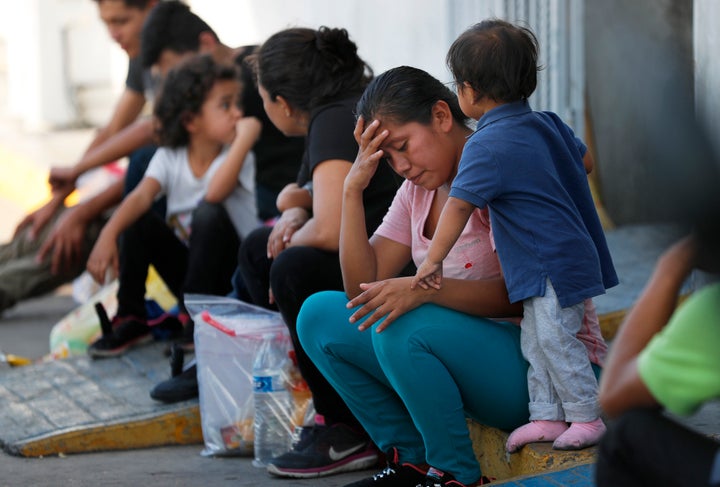 In this July 16, 2019, file photo, migrants wait at an immigration center on the International Bridge 1, in Nuevo Laredo, Mexico. 