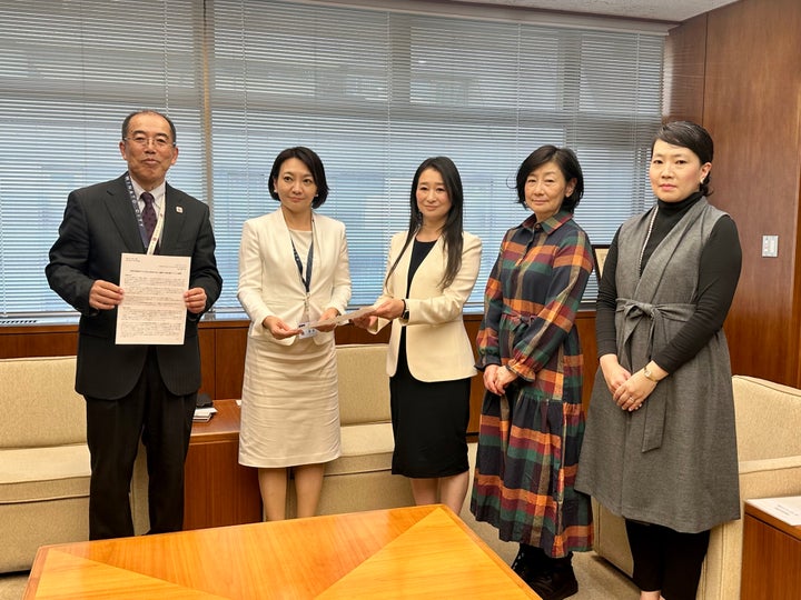 港区の清家愛区長（左から2番目）に要請書を手渡す有志の会代表の加藤渚さん（中央）