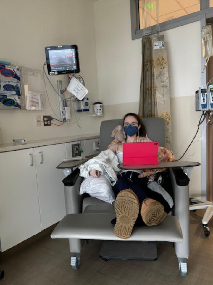 Natalie getting an infusion. "This is what it looks like when you are too comfortable in that infusion chair, because you are there every week — and it's the only time you leave the house," the author writes.