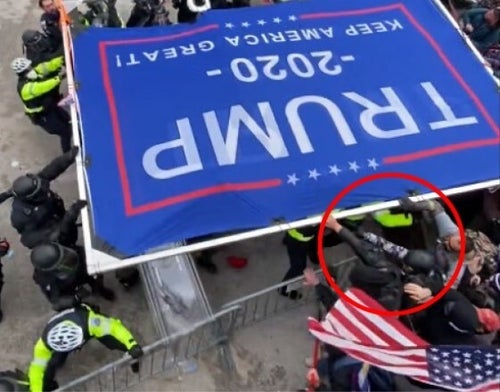Justice Department exhibit depicting Lee Stutts allegedly grabbing hold of large sign he used as a battering ram against police defending the Capitol on Jan. 6, 2021.