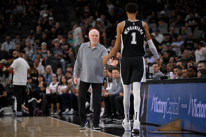 San Antonio Spurs head coach Gregg Popovich greets Spurs forward Victor Wembanyama as he walks off of the court during the first half of an NBA basketball game against the Houston Rockets, Monday, Oct. 28, 2024, in San Antonio. (AP Photo/Darren Abate)