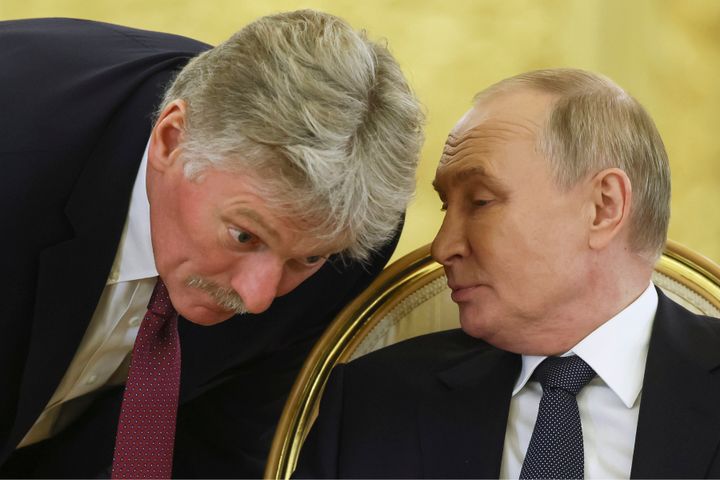 Russian President Vladimir Putin, right, speaks with Kremlin spokesman Dmitry Peskov