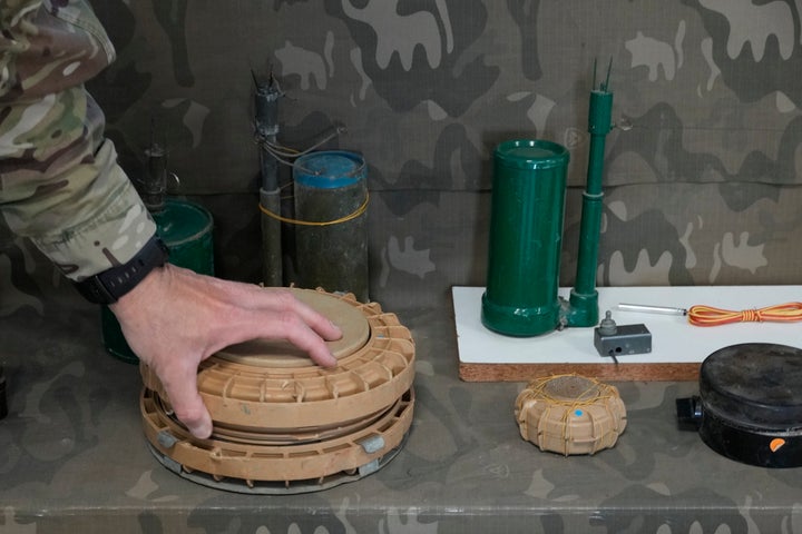 A Cypriot National Guardsman handles an inert landmine that is part of a display of inert rockets, artillery shells and other munitions as part of a training course of Ukrainian personnel in the disposal of landmines and other explosive ordnance in Cyprus, at an army base, in Nicosia, Thursday, Nov. 14, 2024. (AP Photo/Petros Karadjias)