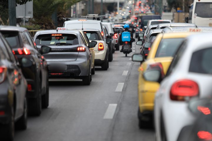 Δίκυκλο ανάμεσα σε οχήματα ακινητοποιημένα εν μέσω κυκλοφοριακής συμφόρησης.