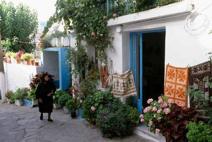 Ηλικιωμένη περιδιαβαίνει τους δρόμους στα Ανώγεια της Κρήτης.