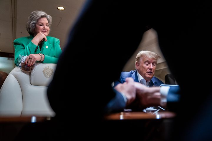 Susie Wiles stands by as Donald Trump speaks to staff and reporters aboard his airplane on June 10, 2023.