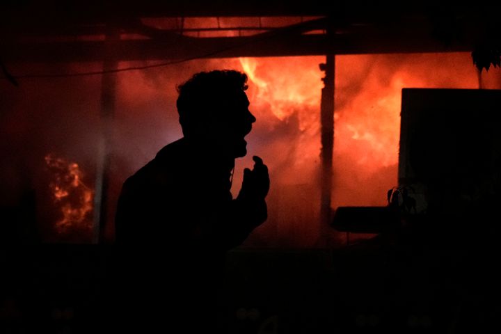 A man screams in front a fire erupting inside a computer shop hit during an Israeli airstrike in central Beirut, Sunday, Nov. 17, 2024. (AP Photo/Bilal Hussein)