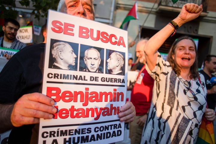 A protester holds a placard with the face of Israeli Prime Minister Benjamin Netanyahu during a demonstration in front of the U.S. Embassy in Madrid to demand that the United States comply with the mandate of the International Criminal Court to arrest Israeli Prime Minister Benjamin Netanyahu for war crimes. 