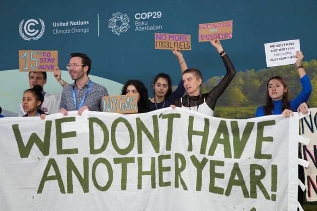 Activists participate in a demonstration with a sign that says 