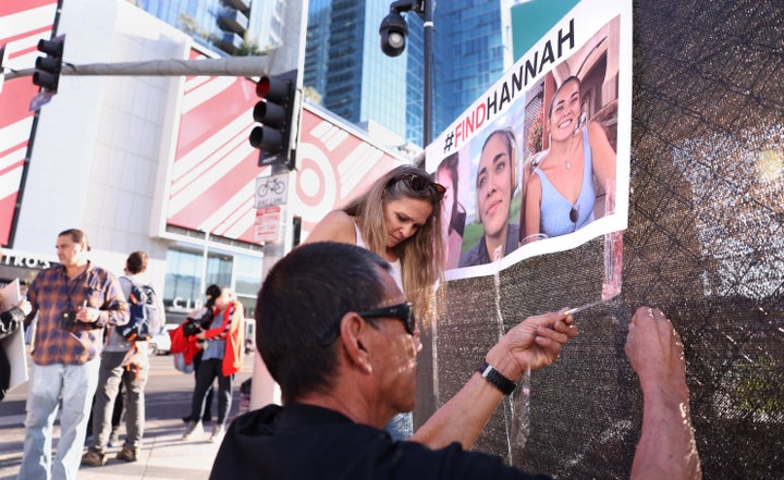 Volunteers put up flyers for missing Maui woman Hannah Kobayashi outside Crypto.com Arena in downtown Los Angeles on Thursday.