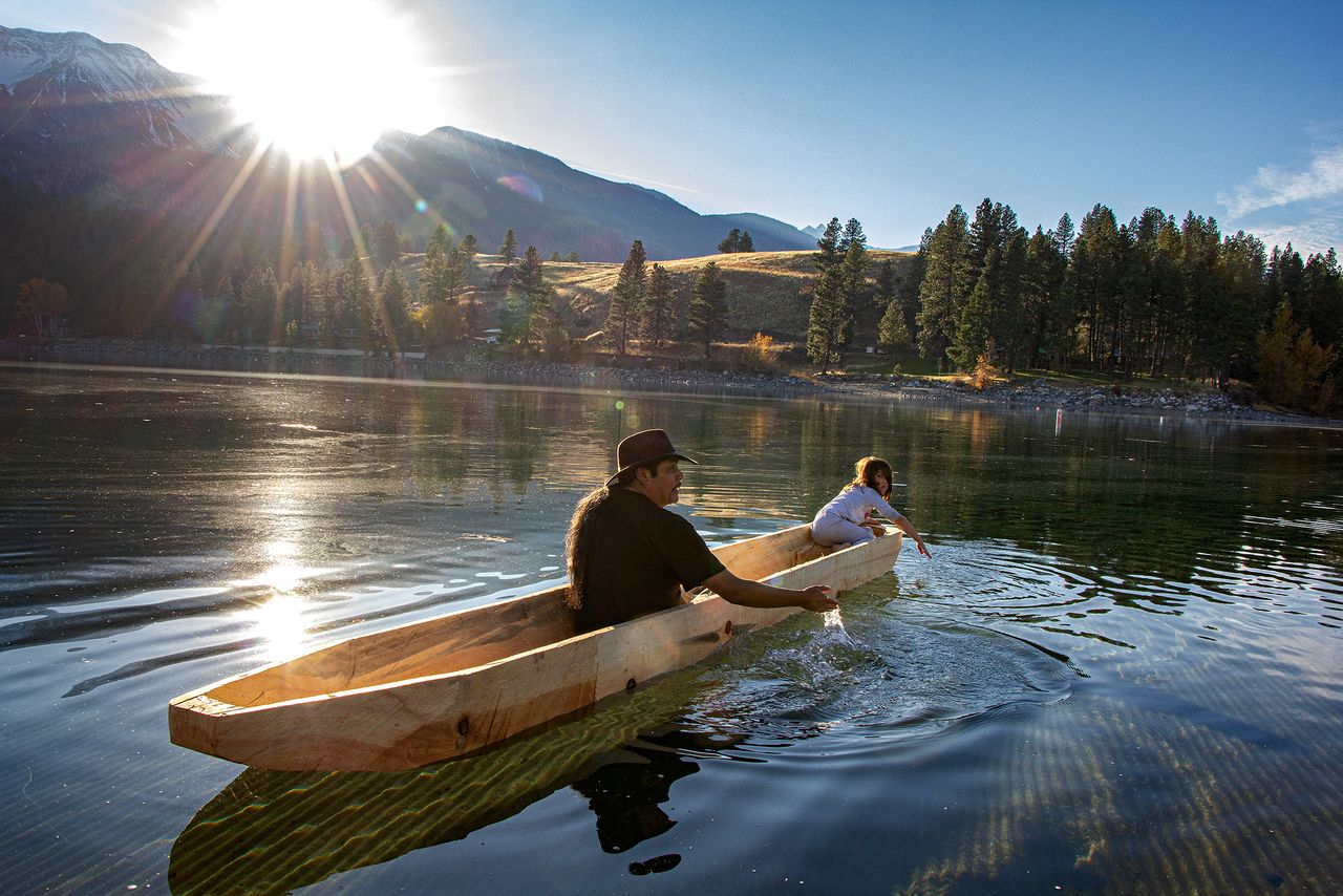 Nez Perce tribal member, Allen Pinkham Jr., and his granddaughter, Lily, test a newly-carved dugout canoe on the waters of Wallowa Lake, Oregon, in 2017. This was the first time a traditional Nez Perce dugout canoe had floated on Wallowa Lake’s waters since their ancestors were forced from that area during the Nez Perce War of 1877. Allen has been working to revive Nez Perce canoe culture for several years as a way to bring awareness to efforts to remove the dams on the Columbia and Snake Rivers to support salmon health and other aquatic river species, and the overall health of the rivers themselves. The canoe-making process involves carrying on ancient knowledge about the way trees grow and water flows that upholds sustainable practices of relationship to the land.