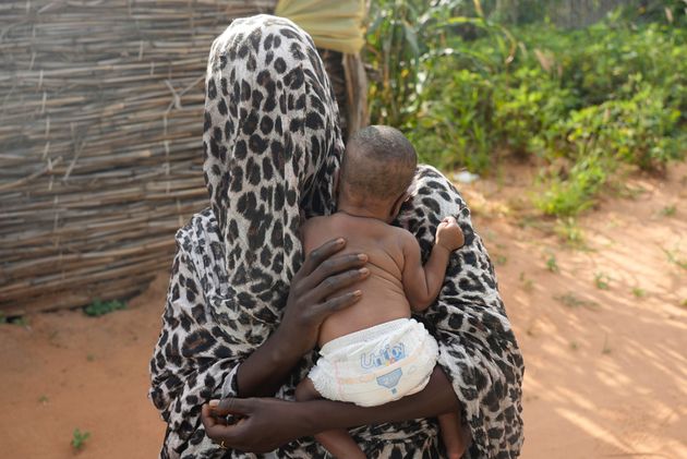 チャドの難民キャンプで赤ちゃんを抱えるスーダンの女性。性的搾取を受けたが報復を恐れて顔や名前を明かさなかった